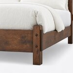Footboard close-up of a Mission slat bed, showing a chamfered square post with round pegs beside the low plank footboard.