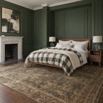 Diagonal angled room view showing the left side of a contemporary platform bed with splayed legs, in a green-paneled room.