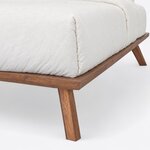 Foot corner close-up of a contemporary platform bed, showing the mitered frame corner over an angled, splayed leg.