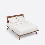 High angled view of a contemporary platform bed, looking down on the panel headboard, thin low frame and splayed legs.