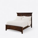 Diagonal angled view showing the left side of a classic panel bed, with a crowned headboard and a low arched footboard.