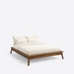 Diagonal angled view showing the right side of a mid-century platform bed, with no headboard and splayed legs.