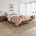 Diagonal angled room view showing the right side of a mid-century platform bed with splayed legs, in a coastal bedroom.