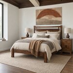 Diagonal angled room view showing the left side of a modern panel bed with splayed legs, in a coffered white bedroom.