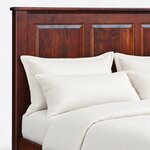 Headboard close-up of a classic storage bed, showing beveled recessed panels, a square post and a rounded cap rail.