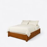 Diagonal angled view showing the left side of a modern platform bed, with three side drawers and a low solid footboard.