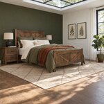 Diagonal angled room view showing the right side of a rustic panel bed with a braced footboard, in an olive-walled bedroom.