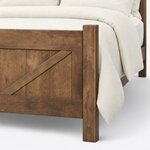 Footboard close-up of a rustic panel bed, showing a square post above the top rail and a brace on vertical planks.