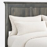 Headboard close-up of a transitional panel bed, showing the stepped crown cap, a square upright and recessed flat panels.