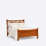 Angled view of a transitional panel bed in a reddish-brown finish, with a cut-out headboard and solid panel footboard.