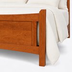 Footboard close-up of a transitional panel bed in a reddish-brown finish, showing a chamfered post beside a cut-out.