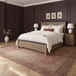 Diagonal angled room view showing the left side of a Shaker storage bed with side drawers, in a plum-paneled bedroom.