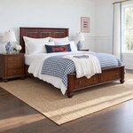 Diagonal angled room view showing the right side of a traditional storage bed with drawers, in a white wainscoted bedroom.