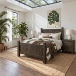 Diagonal angled room view showing the left side of a farmhouse panel bed with square posts, in a skylit white bedroom.