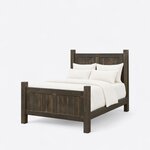 Diagonal angled view showing the left side of a farmhouse panel bed, with a paneled headboard and footboard on square posts.