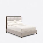 Diagonal angled view showing the right side of a modern upholstered bed, with a framed panel headboard and tapered feet.