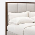 Headboard close-up of a modern upholstered bed, showing squared upholstered panels set inside a slim frame and square post.