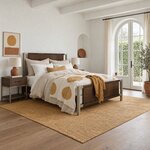 Diagonal angled room view showing the right side of a modern panel bed with metal posts, in a bedroom with arched doors.