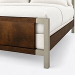 Footboard close-up of a modern panel bed, showing a square metal corner leg, an open bracket and the side rail joint.