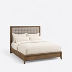 Diagonal angled view showing the right side of a contemporary upholstered bed, with a wide-framed button-tufted headboard.