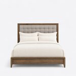 Front view of a contemporary upholstered bed, showing a wide-framed button-tufted headboard and a low panel footboard.