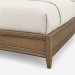 Footboard close-up of a contemporary upholstered bed, showing a molded recessed panel, square corner post and tapered leg.