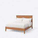 Diagonal angled view showing the left side of a mid-century panel bed, with a low footboard and tapered square legs.