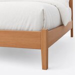 Footboard close-up of a mid-century panel bed, showing a square corner post over a tapered leg and the plain low footboard.