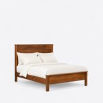 Diagonal angled view showing the right side of a transitional panel bed, with a plank headboard and a low capped footboard.