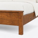 Footboard close-up of a transitional panel bed, showing the overhanging footboard cap, a square leg and the plain side rail.