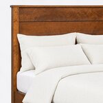 Headboard close-up of a transitional panel bed, showing wide horizontal planks beside a square post under a slim cap.