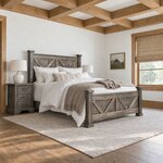 Diagonal angled room view showing the right side of a rustic panel bed with V-braced panels, in a timber-beamed bedroom.