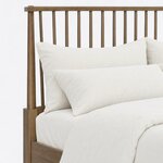 Headboard close-up of a Windsor spindle bed, showing round spindles under a flat cap rail and a tapered round post.