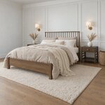 Diagonal angled room view showing the left side of a Windsor spindle bed with a low footboard, in a white paneled bedroom.