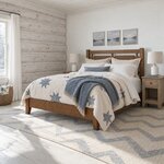 Diagonal angled room view showing the left side of a farmhouse panel bed with an open-panel headboard, in a log cabin.