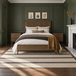 Front room view of a modern panel bed with a two-panel headboard, in a green-paneled bedroom with a fireplace.
