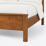 Footboard close-up of a farmhouse panel bed, showing the overhanging cap rail, a square corner leg and the side rail joint.