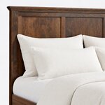 Headboard close-up of a Shaker panel bed, showing a layered cornice over recessed flat panels beside a square post.