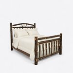 Diagonal angled view showing the right side of a rustic log bed, with an arched sunburst headboard and a spindle footboard.