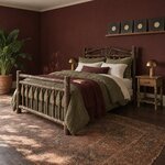 Diagonal angled room view showing the left side of a rustic log bed with a spindle footboard, in a burgundy-walled bedroom.