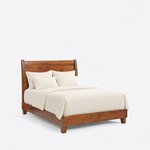 Diagonal angled view showing the right side of a contemporary sleigh bed, with curved head posts and a low footboard.