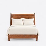 Front view of a contemporary sleigh bed, showing a tall plank headboard, flared posts and a low footboard on tapered legs.