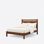 Diagonal angled view showing the left side of a modern panel bed, with an open-slot headboard and a low footboard.