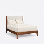 Diagonal angled view showing the right side of a modern upholstered bed, with an upholstered headboard and tapered legs.