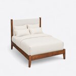 High angled view of a modern upholstered bed, looking down on the upholstered headboard, plain side rails and low footboard.