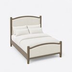 High angled view of an Art Deco upholstered bed, looking down on the arched footboard, plain side rails and tapered legs.