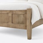 Footboard close-up of a modern panel bed, showing recessed panels, a curved top rail and a square post on a tapered leg.