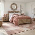 Diagonal angled room view showing the right side of a modern panel bed with a three-panel footboard, in a white bedroom.