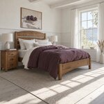 Diagonal angled room view showing the right side of a modern slat bed with an arched headboard, in a white lake-view bedroom.