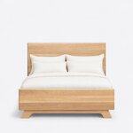Front view of a contemporary panel bed, showing a tall slab headboard and a low slab footboard on wide splayed feet.